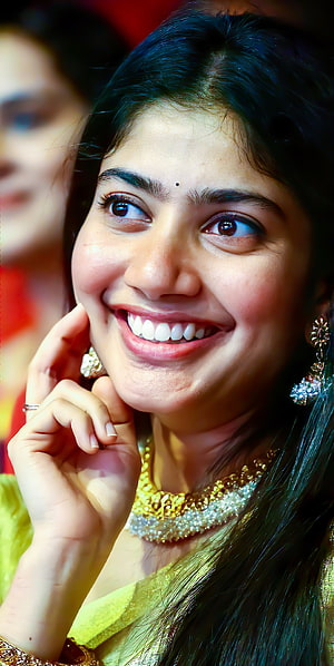 Sai Pallavi smiling portrait wearing traditional gold jewelry and green saree HD phone wallpaper