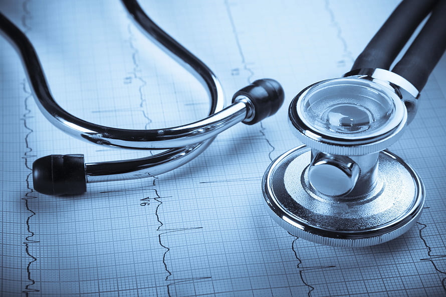 Stethoscope Resting on ECG Heartbeat Chart with Medical Grid Background HD wallpaper