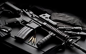 Tactical AR-15 Rifle with Flashlight, Laser, and Ammo on Black Surface HD wallpaper