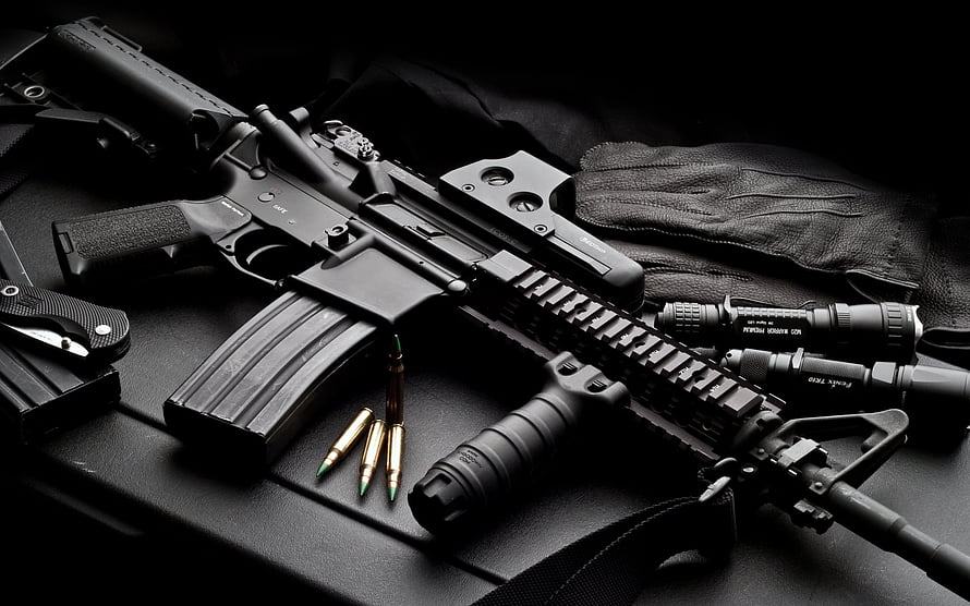 Tactical AR-15 Rifle with Flashlight, Laser, and Ammo on Black Surface HD wallpaper
