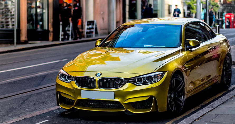 Vibrant Yellow BMW M4 Coupe Parked on a City Street HD wallpaper