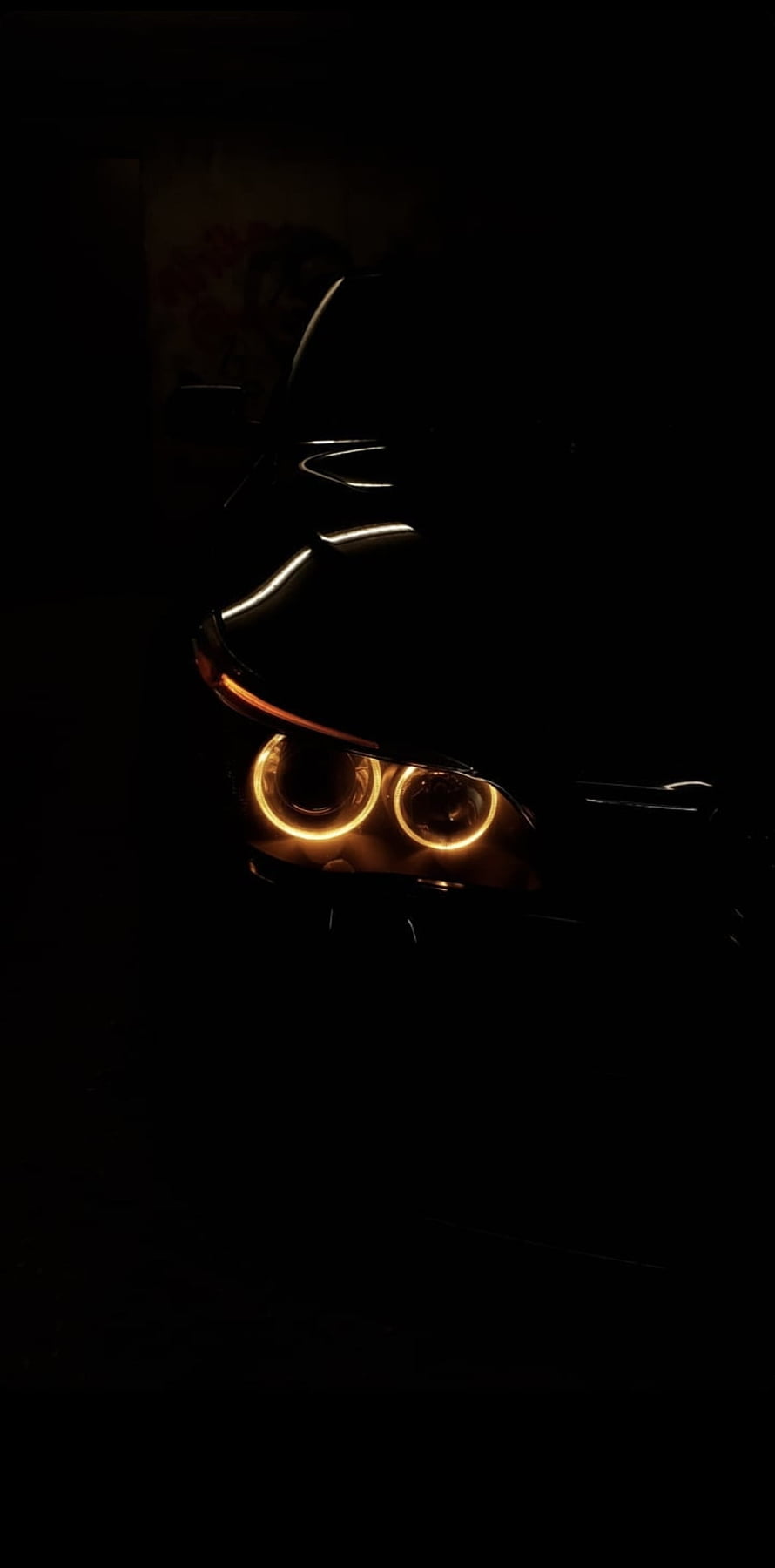 Close-Up of Car Headlights with Glowing Amber Halo Rings in Dark Night Setting HD phone wallpaper