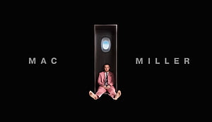 Mac Miller in a Pink Suit Seated Inside a Coffin Against a Black Background HD wallpaper