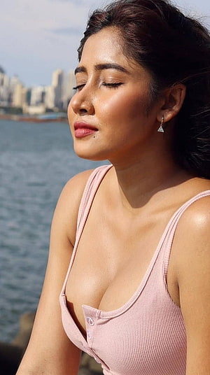 Sara Ali Khan in a pink top with eyes closed near the water HD phone wallpaper