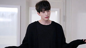 Lee Dong Wook in a black sweater with arms outstretched in a bright indoor setting HD wallpaper