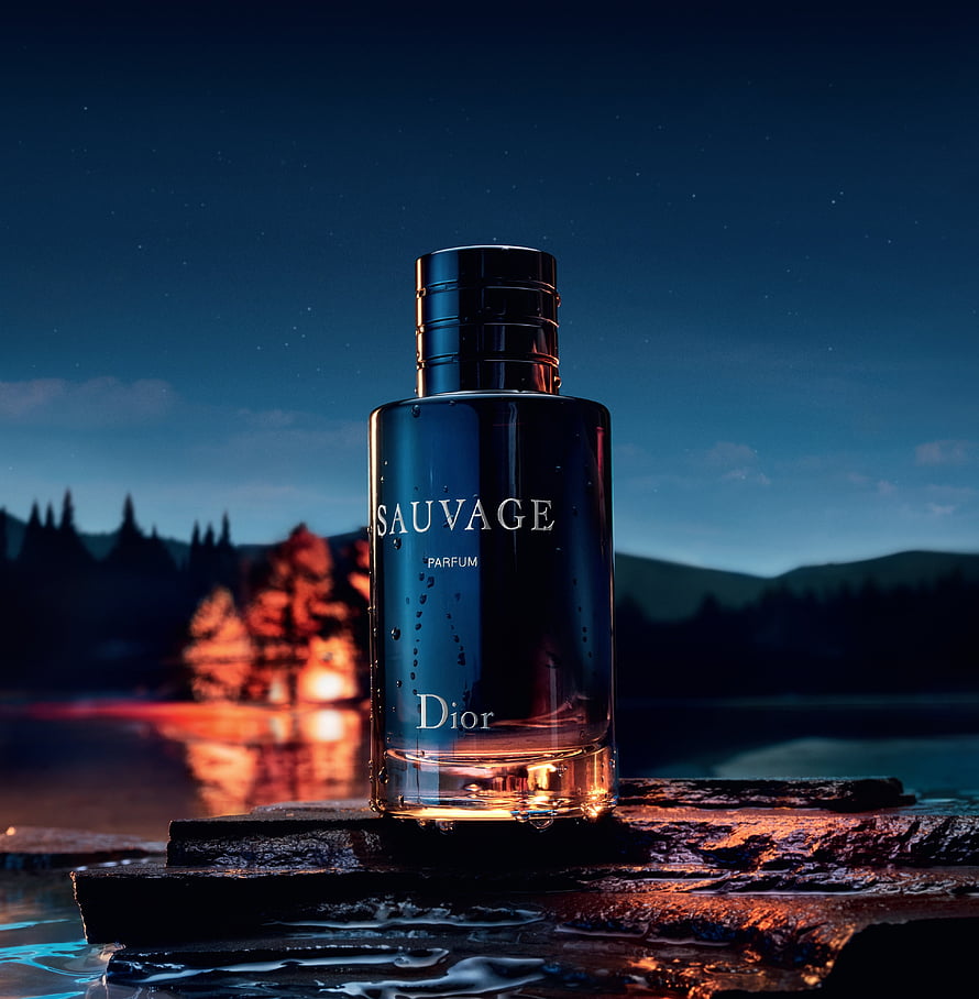 Dior Sauvage Parfum Bottle on Wet Rocks at Night with Campfire Glow and Starry Sky HD phone wallpaper