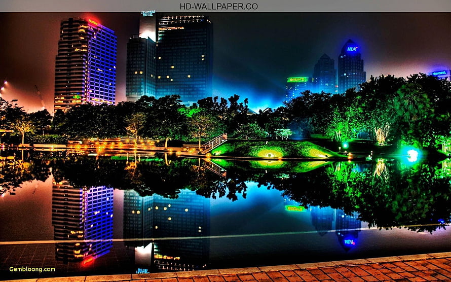 Vibrant Night Cityscape with Colorful Skyscrapers Reflected in a Park Lake HD wallpaper