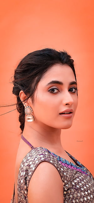 Priyanka Mohan Portrait in Traditional Attire with Statement Earrings Against Orange Background HD phone wallpaper