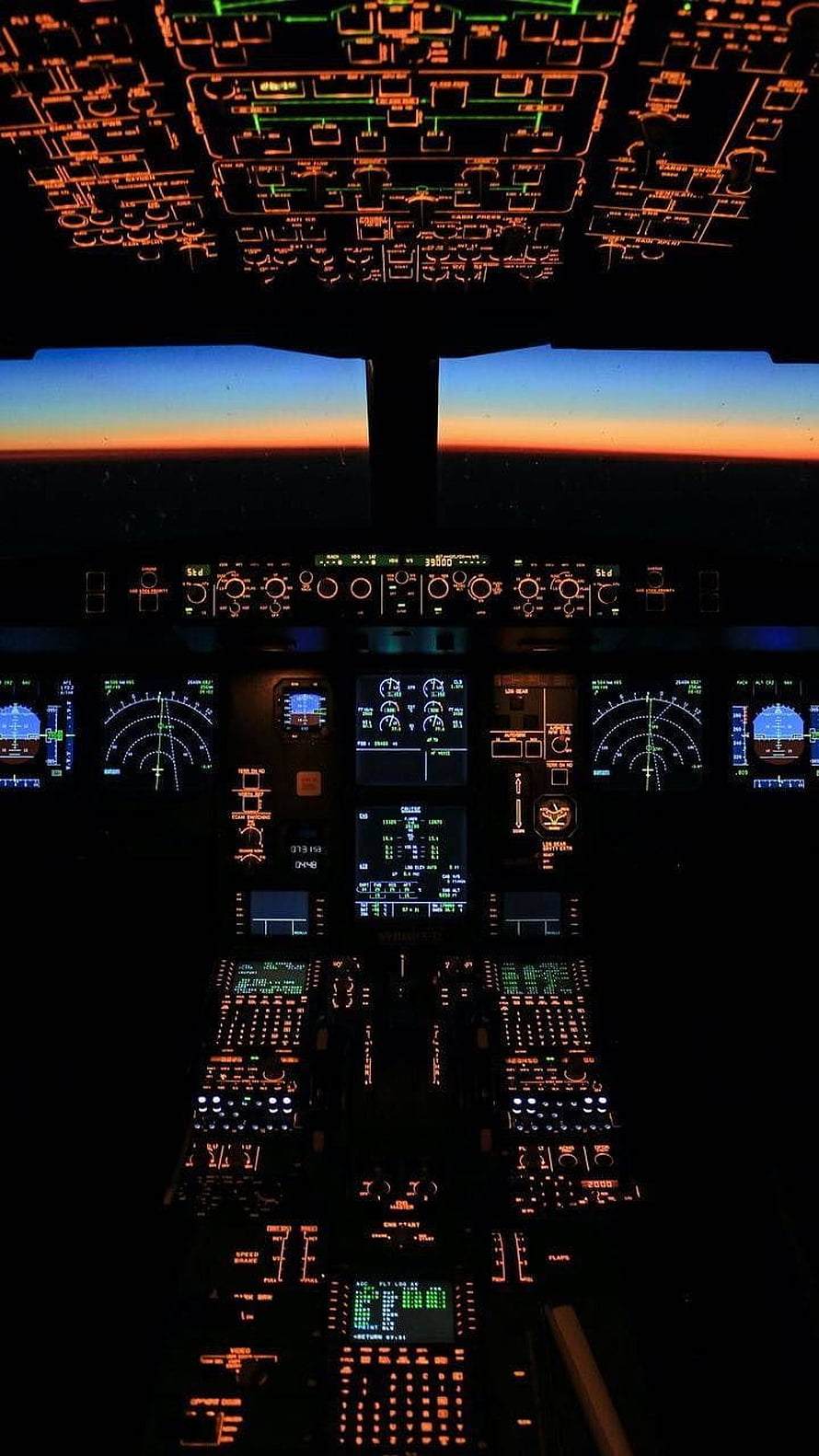 Commercial Airplane Cockpit at Night with Glowing Instrument Panels and Sunset Horizon View HD phone wallpaper