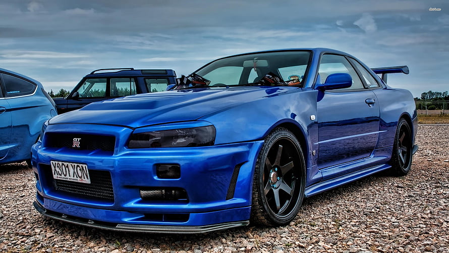 Blue Nissan Skyline GT-R R34 Widebody Coupe with Rear Spoiler on Gravel HD wallpaper
