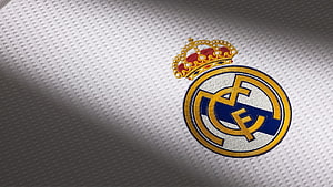 Real Madrid CF embroidered club crest on white textured football jersey fabric HD wallpaper