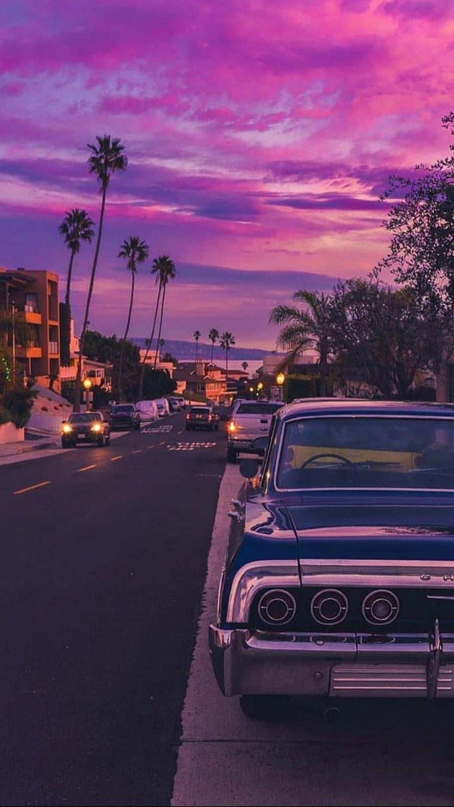 Vintage Blue Classic Car Parked on Street with Palm Trees Under Purple Sunset Sky HD phone wallpaper