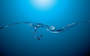 Dynamic Water Wave Splash on Deep Blue Gradient Background HD wallpaper