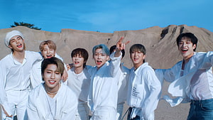 Stray Kids in white outfits posing outdoors against a rocky desert landscape under a clear blue sky HD wallpaper