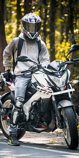 Rider on a White Bajaj Pulsar NS200 Motorcycle in a Forest Setting HD phone wallpaper