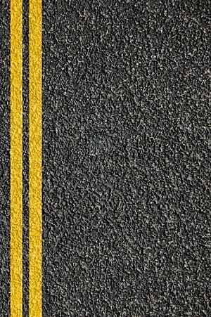 Close-up of dark asphalt road surface with double yellow center lines HD phone wallpaper