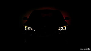 Mysterious Car Silhouette with Glowing Angel Eye Headlights in the Dark HD wallpaper