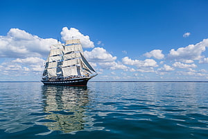 Majestic Tall Ship Sailing on Calm Blue Ocean Under Cloudy Sky HD wallpaper