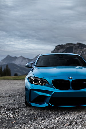 Blue BMW M2 Competition parked on gravel road with mountains HD phone wallpaper