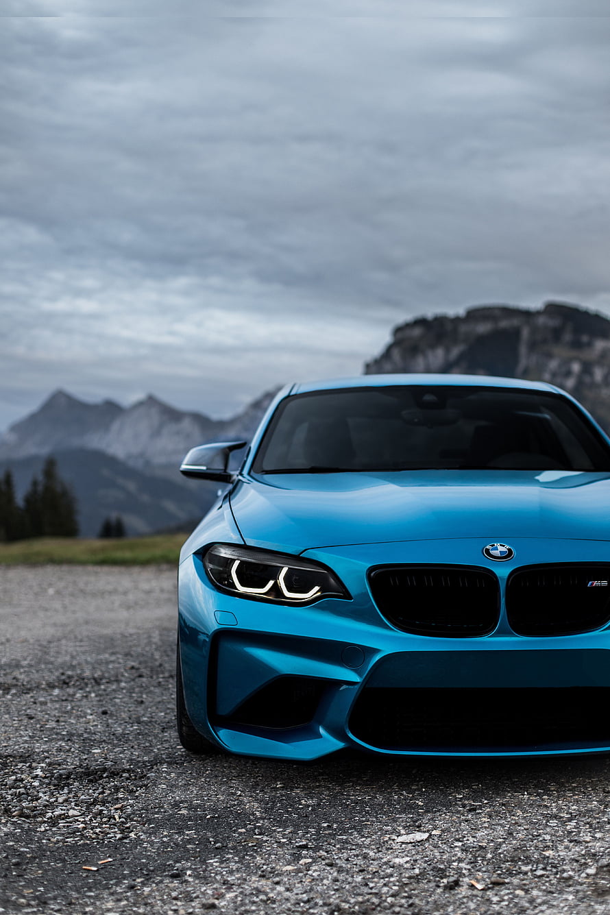 Blue BMW M2 Competition parked on gravel road with mountains HD phone wallpaper