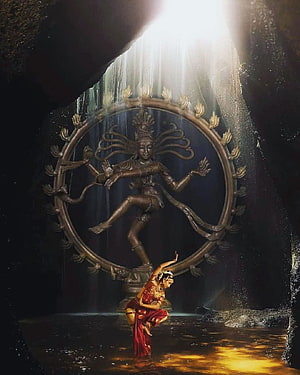 Bharatanatyam dancer performing before a Nataraja statue in a sunlit cave HD phone wallpaper