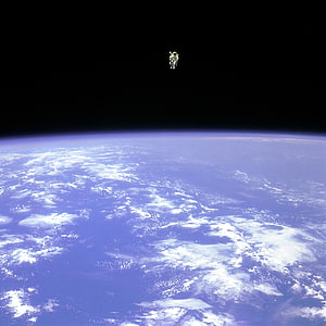 Astronaut Bruce McCandless II Floating in Space Above Earth's Cloudy Horizon HD phone wallpaper