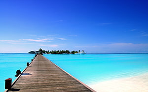 Serene Wooden Pier Extending Over Turquoise Lagoon Waters Towards Tropical Island HD wallpaper