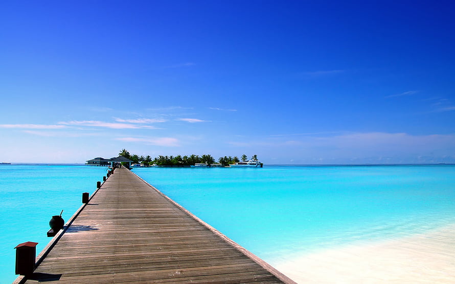 Serene Wooden Pier Extending Over Turquoise Lagoon Waters Towards Tropical Island HD wallpaper