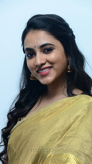 Priyanka Arul Mohan in a mustard yellow saree with gold jhumka earrings and a soft smile HD phone wallpaper