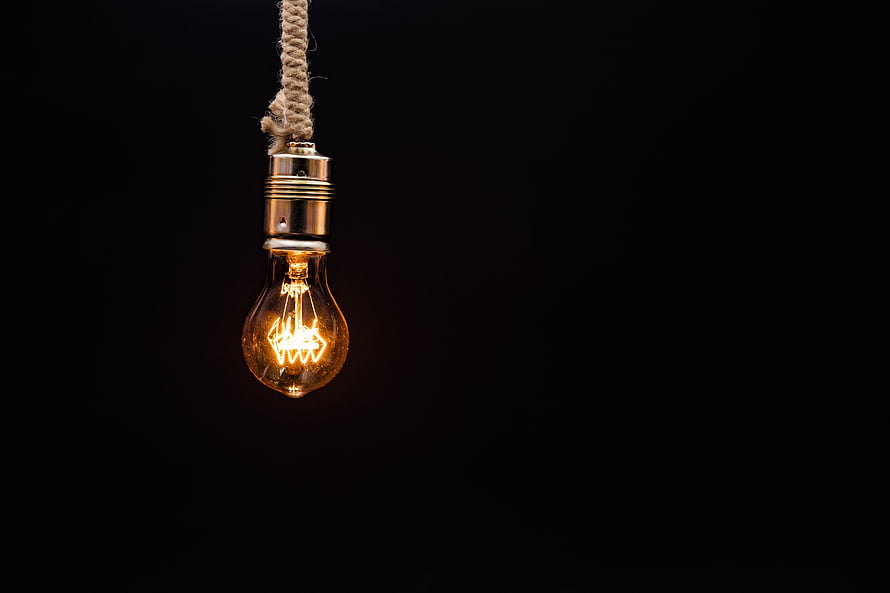 Glowing Edison Bulb Hanging From Twisted Rope Against Dark Background HD wallpaper