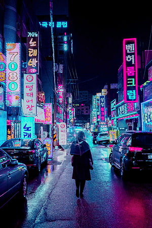 Neon-lit Korean street at night with a lone figure walking under an umbrella, reflecting vibrant pink and blue lights on wet pavement HD phone wallpaper