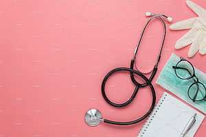 Medical stethoscope, face mask, and gloves on pink background HD wallpaper