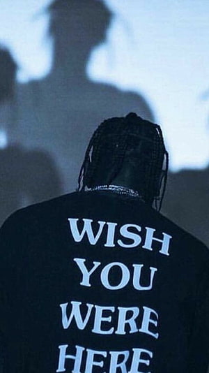 Travis Scott from behind wearing a black shirt with white text and a large shadow on the wall HD phone wallpaper