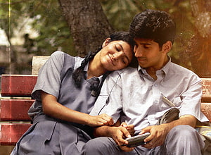 Mudhal Nee Mudivum Nee: Romantic Couple Sharing Earphones on a Park Bench HD wallpaper