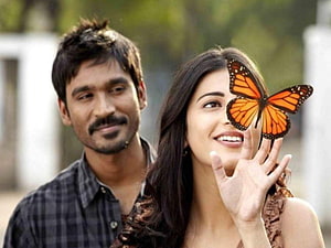 Shruti Haasan and Dhanush with a monarch butterfly in a romantic outdoor portrait HD wallpaper