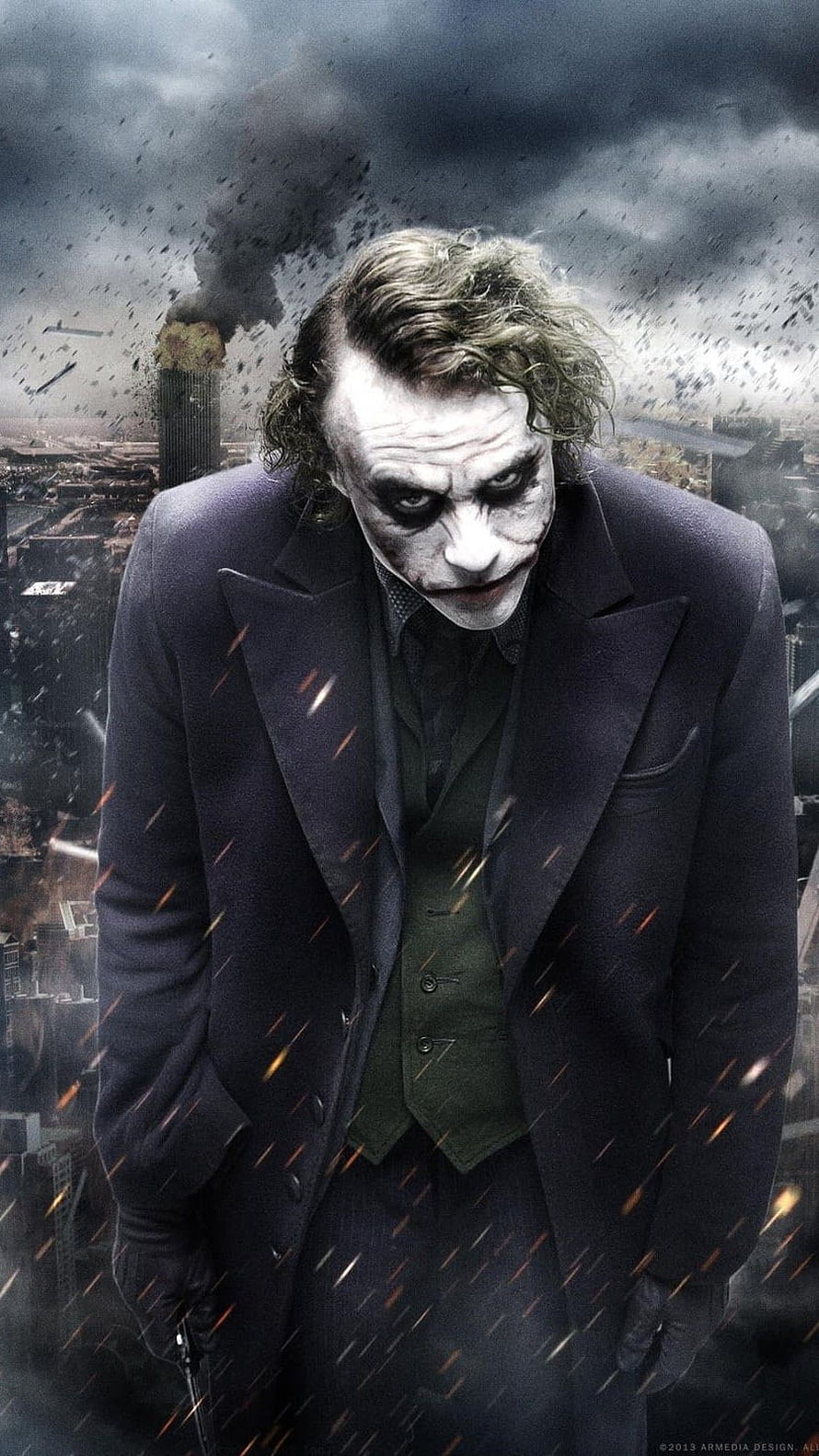 The Joker from The Dark Knight Rises standing before a burning cityscape with falling embers and smoke HD phone wallpaper