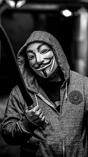 Anonymous Guy Fawkes Mask Hooded Figure Holding Sword in Black and White HD phone wallpaper