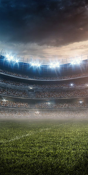Atmospheric Night View of a Packed Football Stadium with Bright Floodlights HD phone wallpaper