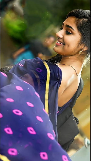 Krithi Shetty in a navy blue saree with pink motifs and gold trim, smiling in profile HD phone wallpaper