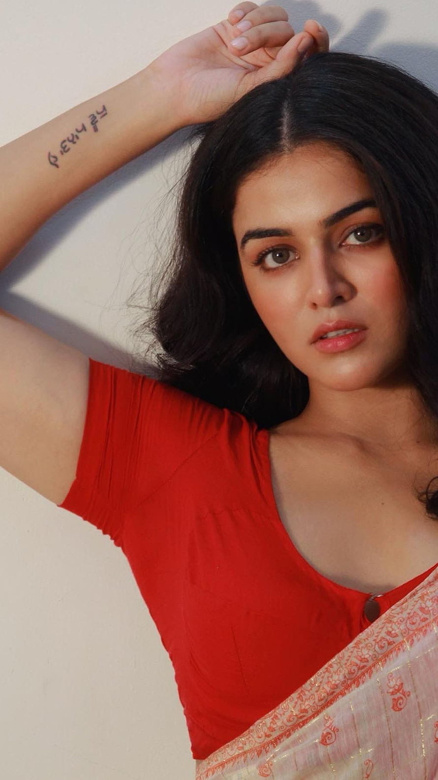 Wamiqa Gabbi in a red blouse with a white patterned dupatta against a plain wall HD phone wallpaper