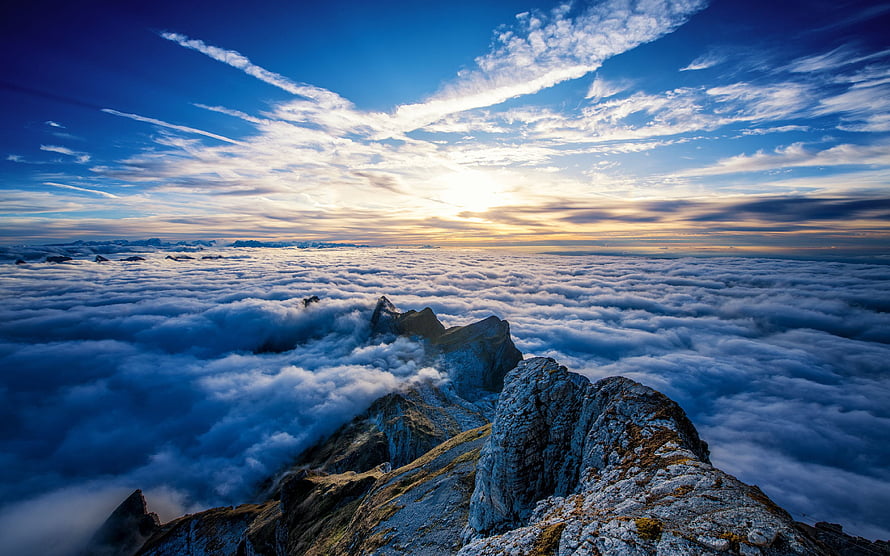 Majestic Mountain Peaks Rising Above a Sea of Clouds at Golden Hour HD wallpaper
