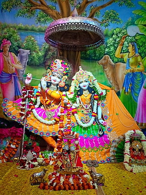 Vrindavan Temple Murti of Radha and Krishna Adorned with Marigold Garlands and Traditional Attire HD phone wallpaper