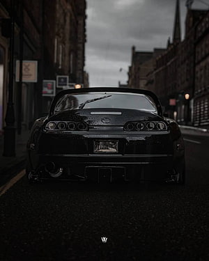 Rear View of a Black Toyota Supra Parked on a Moody Urban Street HD phone wallpaper