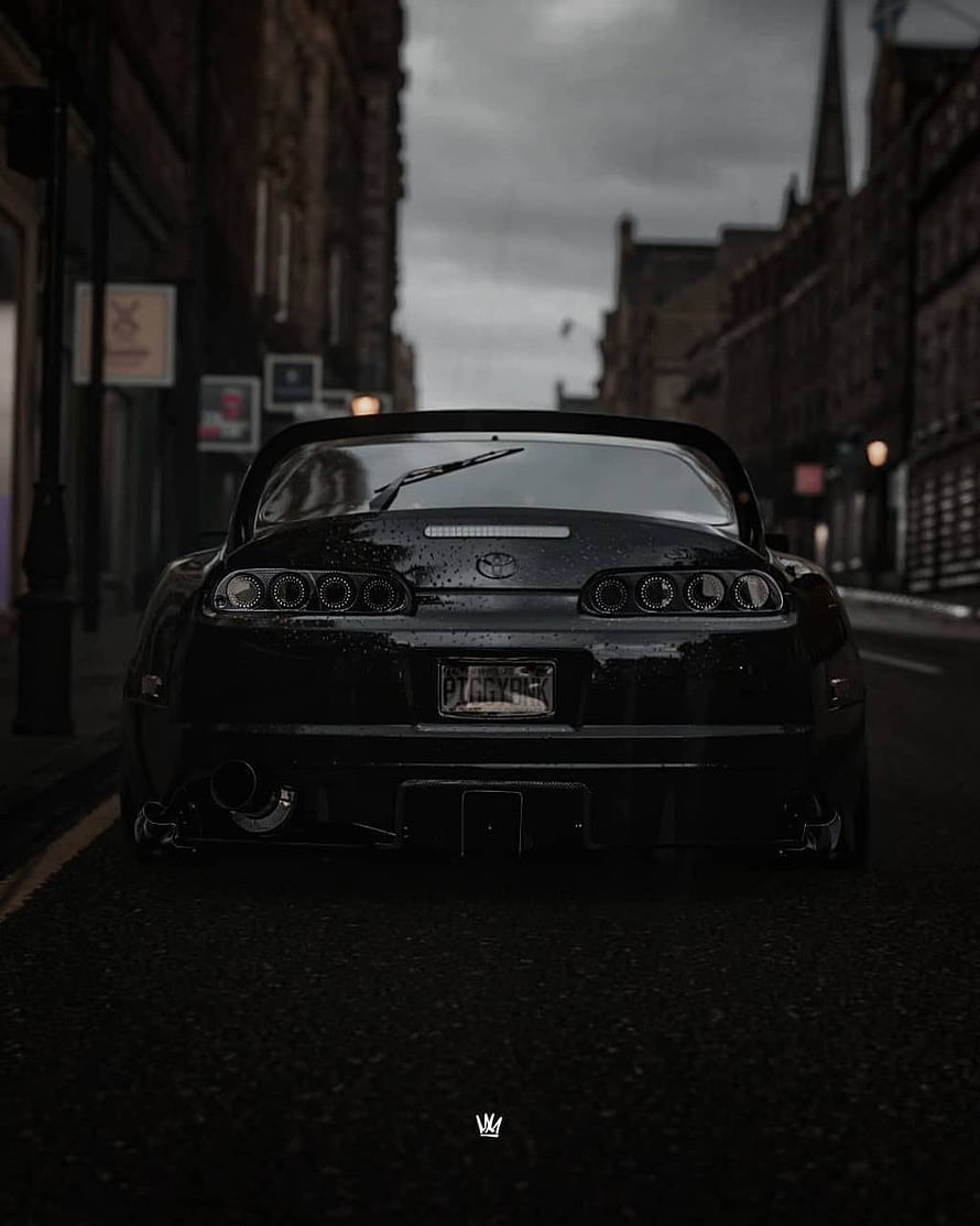 Rear View of a Black Toyota Supra Parked on a Moody Urban Street HD phone wallpaper