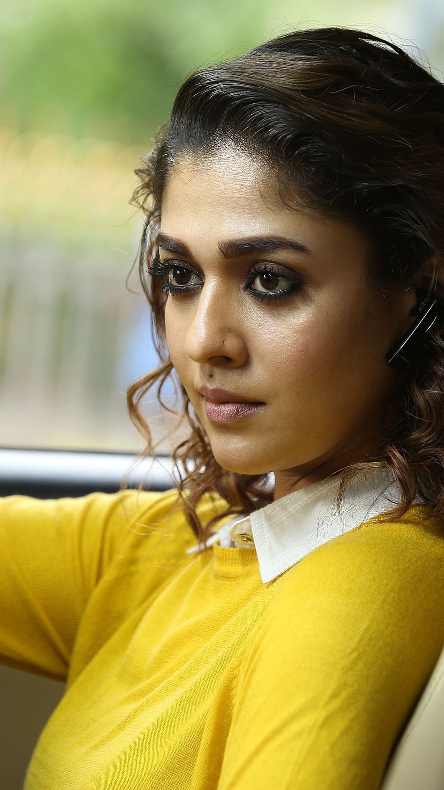 Nayantara in a yellow top with a white collar, seated in a car with a pensive expression HD phone wallpaper