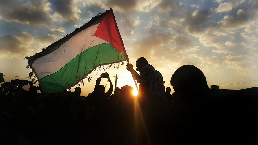 Silhouetted Crowd Waving Palestinian Flag Against Golden Sunset Sky HD wallpaper