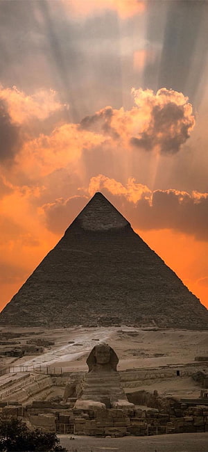 Great Pyramid of Giza and Sphinx at Sunset with Dramatic Clouds and Light Rays HD phone wallpaper