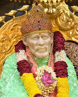 Shirdi Sai Baba Murti Adorned With Floral Garlands And Ornate Crown HD phone wallpaper