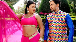 Amrapali Dubey in vibrant pink traditional attire with male co-star in colorful ethnic wear HD wallpaper