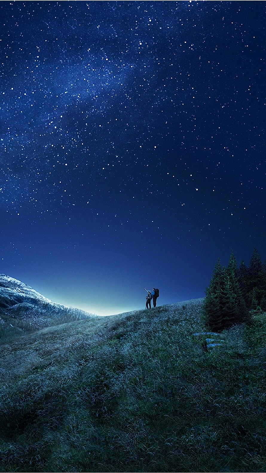 Two Hikers Stargazing on a Grassy Hill Under a Milky Way Night Sky HD phone wallpaper